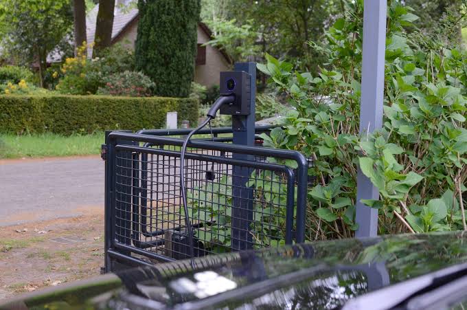Borne de recharge installée sur poteau à l’extérieur, en zone privative