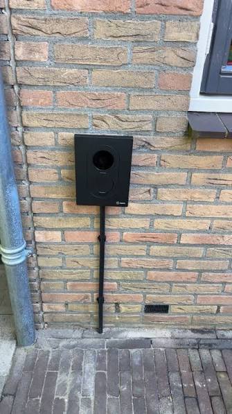 Borne de recharge Zaptec sur pied avec cheminement de câble le long de la façade